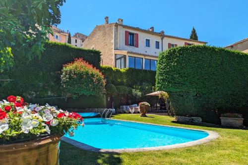 a swimming pool in the yard of a house at Le Clos Du Buis in Bonnieux