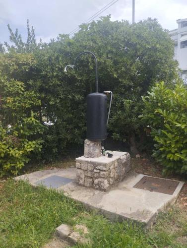 a black tank sitting on top of a stone structure at Apartman Kora in Njivice