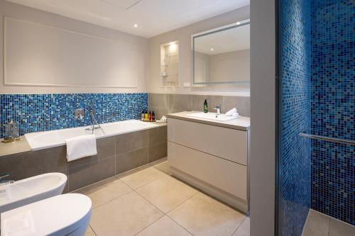 a bathroom with a sink and a tub and a toilet at The Wellem, in The Unbound Collection by Hyatt in Düsseldorf