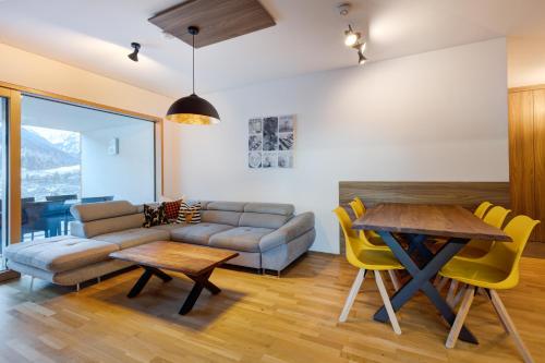 een woonkamer met een bank en een tafel bij Apartment SCHLADMING - Planai view in Schladming