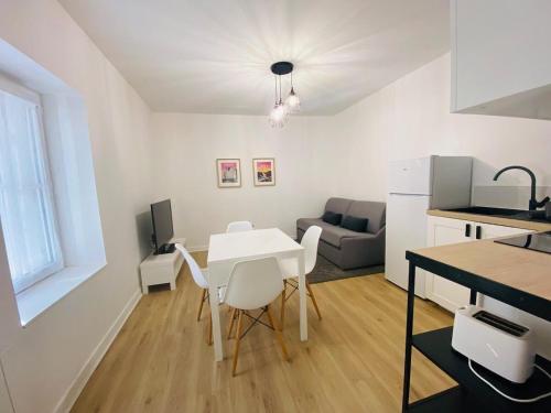 une cuisine et un salon avec une table et des chaises blanches dans l'établissement Casa Jardin des Plantes : T2, à Angers