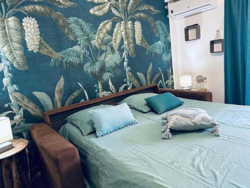 - une chambre avec un lit vert et un papier peint tropical dans l'établissement Joli studio Cap d'Antibes, à Antibes