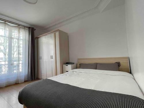 une chambre avec un grand lit et une fenêtre dans l'établissement Appartement confort Paris 15ème, à Paris