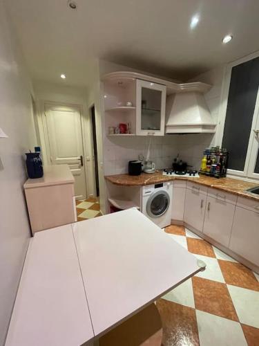 - une cuisine avec une table blanche dans une pièce dans l'établissement Appartement confort Paris 15ème, à Paris