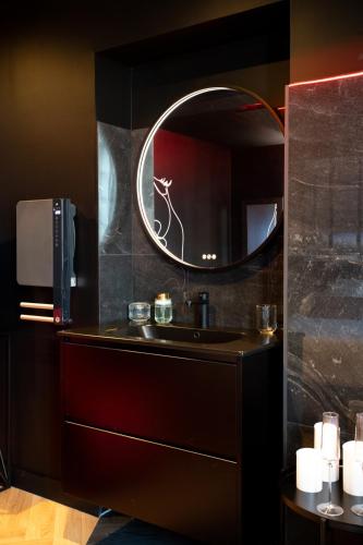 une salle de bain avec un lavabo et un miroir dans l'établissement La Suite Spa & Cinéma, à Saint-Lambert-du-Lattay