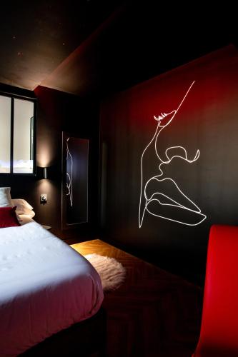 une chambre avec un lit avec un tableau sur le mur dans l'établissement La Suite Spa & Cinéma, à Saint-Lambert-du-Lattay