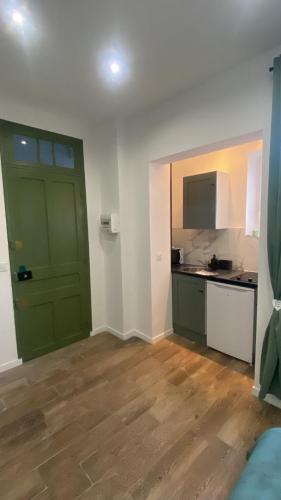 une pièce vide avec une porte verte et une cuisine dans l'établissement Studio Californie beach, à Nice