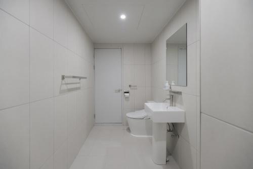 カピョンにあるAank Air Hotel Gapyeongの洗面台とトイレを備えた白いバスルーム