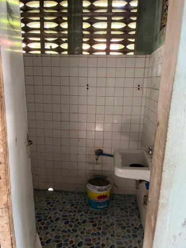 een kleine badkamer met een wastafel en een toilet bij Backpacker's Lodge - Fan Room 1 in Bacnotan