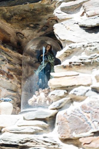 a statue of a woman holding a cross on a wall at Story Studio Piódão - Heritage in Piódão