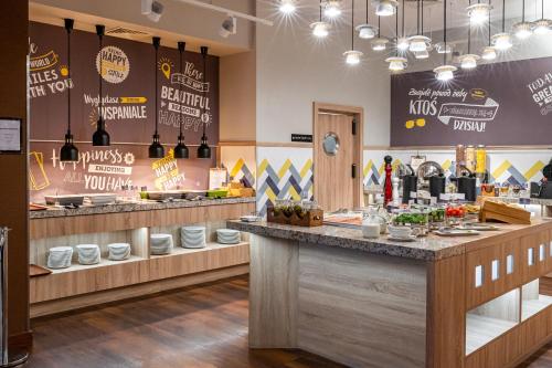 a restaurant with a counter with wine bottles at Hampton by Hilton Warsaw Airport in Warsaw