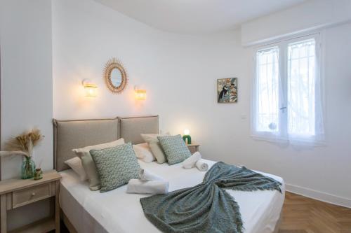 - une chambre blanche dotée d'un lit avec oreillers et d'une fenêtre dans l'établissement L54 1BDR Promenade Sea View AC & Balcony, à Nice