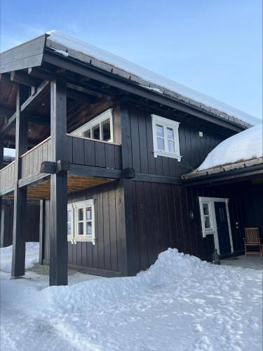 ein Blockhaus mit Schnee davor in der Unterkunft Ullsheim Grendehytte in Beitostøl