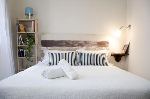 una camera da letto con un letto bianco con due asciugamani sopra di Appartamenti il Giglio a Pistoia