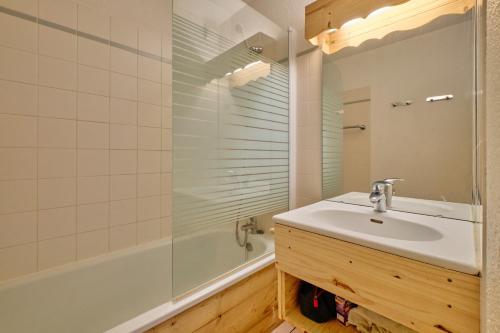 une salle de bain avec un lavabo et une douche dans l'établissement Appartement Alpe D'huez, à Huez