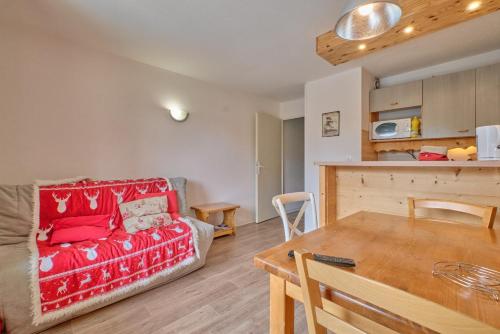 un salon avec un canapé rouge et une table dans l'établissement Appartement Alpe D'huez, à Huez