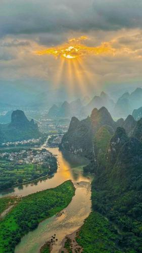 an aerial view of a river with the sun shining at Yangshuo Shui Mo Ju courtyard in Yangshuo
