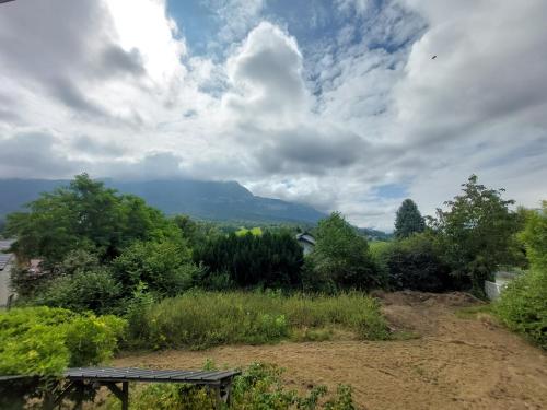 un banc sur une colline avec vue sur la montagne dans l'établissement Maison chalet 80 m2 à Trévignin, à Trévignin