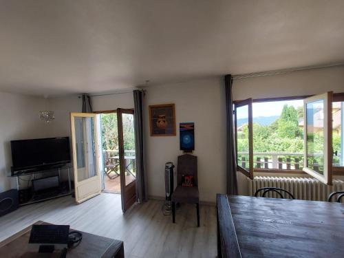 un salon avec une table et une télévision dans l'établissement Maison chalet 80 m2 à Trévignin, à Trévignin