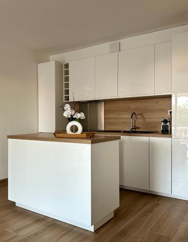 une cuisine avec des placards blancs et un comptoir dans l'établissement T2 Mandelieu Cannes - Résidence calme -piscine - proche commodités, à Mandelieu-la-Napoule