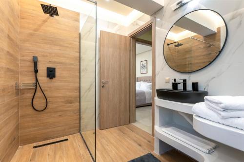 Un baño con ducha, lavabo y espejo. en Villa Hodaj 2, en Afantou