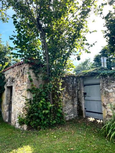 a stone wall with a tree and a garage at Grand family home in the heart of Burgundy! in Saint-Berain-sur-Dheune