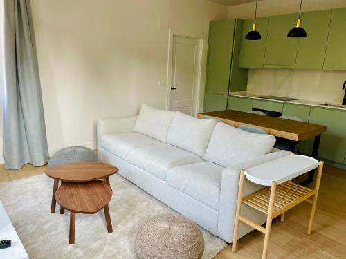 a living room with a white couch and a table at Indiano House Apartments, Muros de Nalón, 5km Cudillero in Muros de Nalón