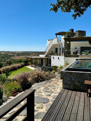 a house with a swimming pool and a wooden bench at Vistas - Herdade do Zambujal in Castro Verde