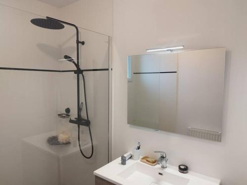 une salle de bain avec une douche, un lavabo et un miroir dans l'établissement maison plein pied de 2023, à Quimerch