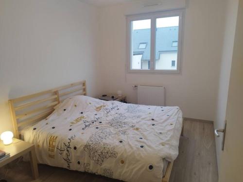 une chambre avec un lit avec une couette et une fenêtre dans l'établissement maison plein pied de 2023, à Quimerch