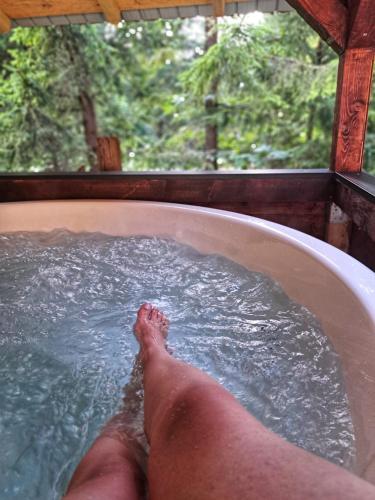 a persons foot in a bath tub with water at Casa Sinca in Timisul de Jos