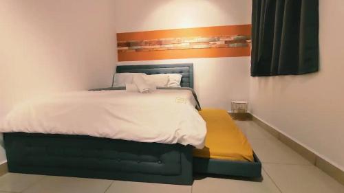 a bedroom with a large bed with an orange and white bed frame at Kulai d'putra suites beside ioiMall near Airport and JPO in Kulai