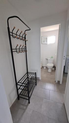 une étagère noire dans une salle de bains pourvue de toilettes. dans l'établissement Maison à la Campagne, à Duclair