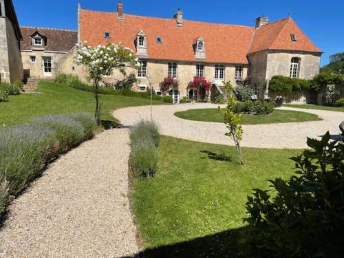 a large building with a garden in front of it at Le Gite Gue Pierreux in Falaise