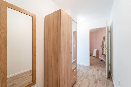 un couloir avec un grand miroir mural dans l'établissement Moulin à Vent A03 - Studio avec terrasse, à Bondy