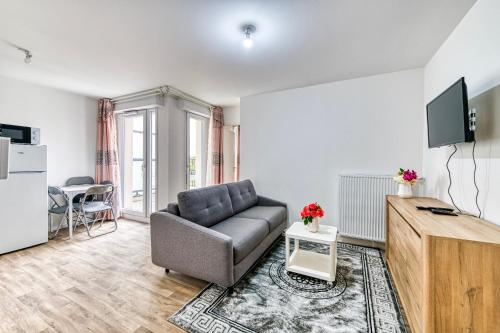 un salon avec un canapé et une télévision dans l'établissement Moulin à Vent A21 - Appt pour 4, à Bondy