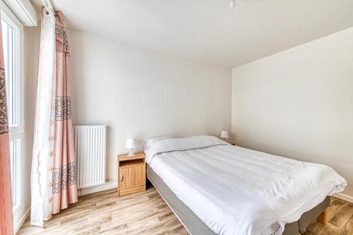 ein weißes Schlafzimmer mit einem Bett und einem Fenster in der Unterkunft Moulin à Vent A21 - Appt pour 4 in Bondy