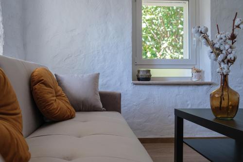 un salon avec un canapé, une table et une fenêtre dans l'établissement Maisonnette de charme, à La Colle-sur-Loup