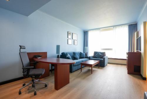 a living room with a couch and a table at Crowne Plaza Antwerpen by IHG in Antwerp