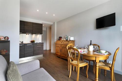 une cuisine et une salle à manger avec une table et des chaises dans l'établissement Au Bord du Lac - Appt 6p vue lac et montagne, à Gérardmer
