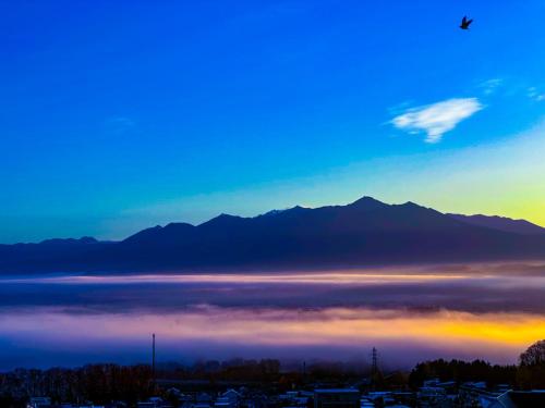 a view of a lake with mountains in the background at Hotel Naturwald Furano in Furano