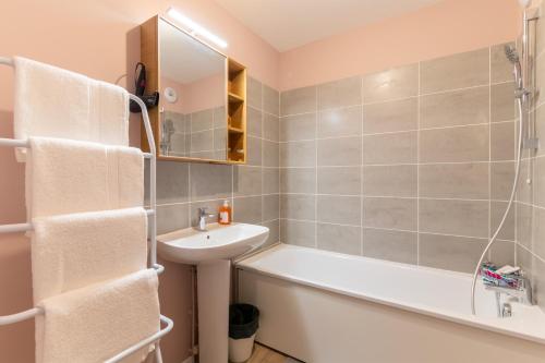 une salle de bain avec un lavabo, une baignoire et des toilettes dans l'établissement Moulin à Vent A22 - Appt pour 4p, à Bondy