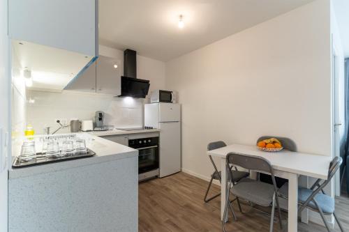 une cuisine avec une table et un comptoir dans l'établissement Moulin à Vent A23 - Appt pour 4p, à Bondy