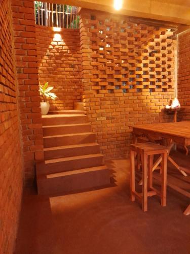 a brick wall with stairs and a wooden table at Wood Palace Ella in Ella