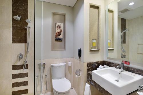 a bathroom with a toilet and a sink and a shower at Holiday Inn Bandung Pasteur by IHG in Bandung
