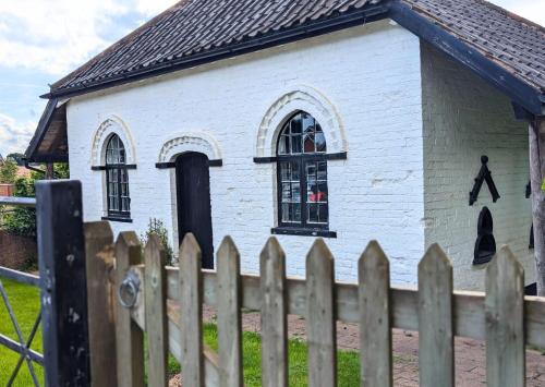 a small white building with a man painted on the side at Cow & Plough Stoughton Grange in Oadby