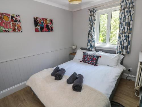 a bedroom with two beds with towels on it at Pinewood in Saundersfoot