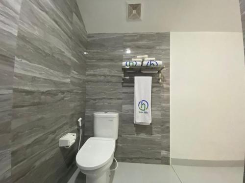 a bathroom with a toilet and a stone wall at Drini Hills Diamond Villa in Brono