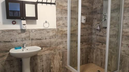 a bathroom with a sink and a shower at Maroela Gardens Guesthouse in Thabazimbi