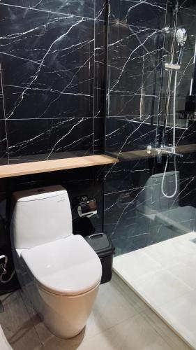 a bathroom with a white toilet and a black wall at Drini Hills Diamond Villa in Brono